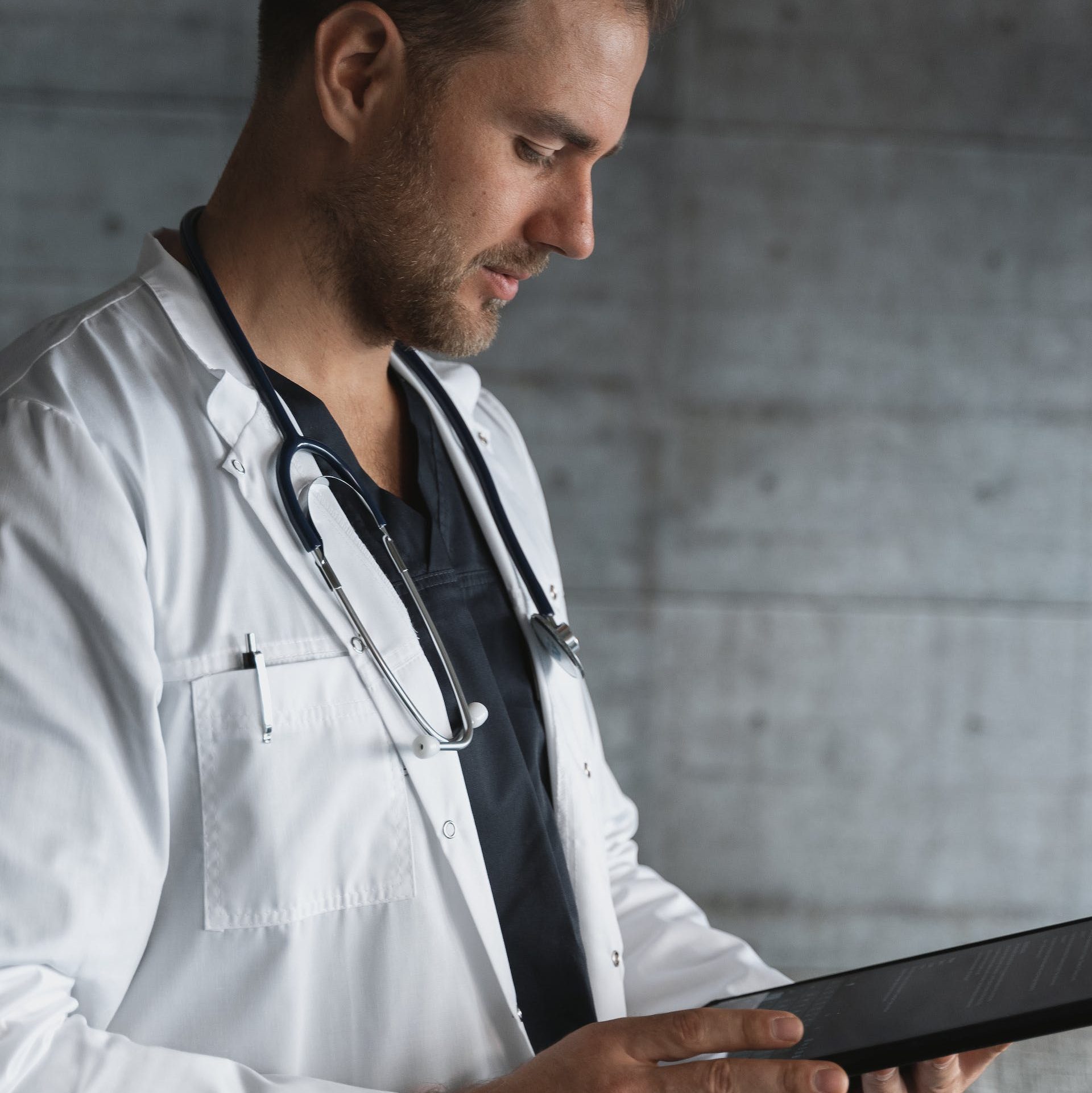 Man in White Button Up Shirt Holding Black Tablet Computer