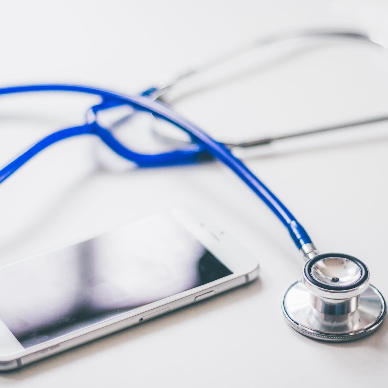 Silver Iphone 6 Near Blue and Silver Stethoscope